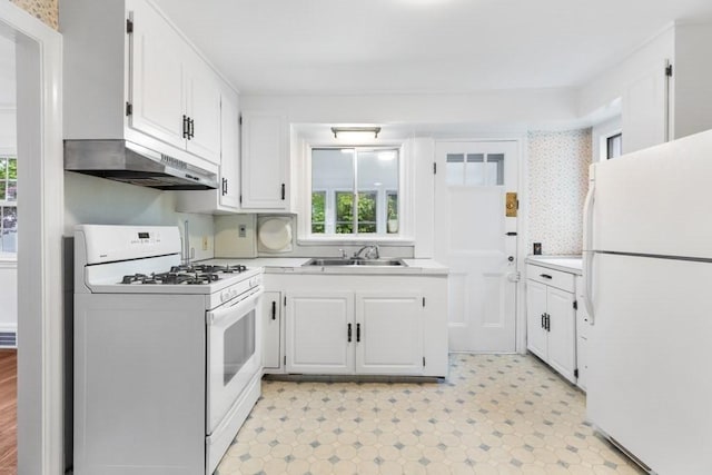 kitchen with white appliances, under cabinet range hood, a sink, white cabinetry, and light countertops