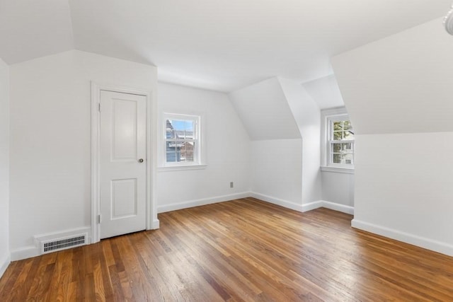 additional living space with lofted ceiling, wood finished floors, and baseboards