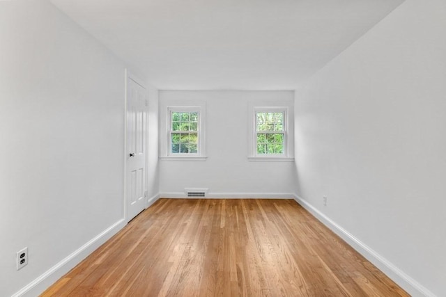 spare room with light wood-style floors and baseboards