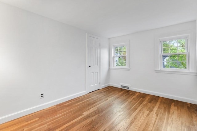 empty room with light wood-style floors and baseboards