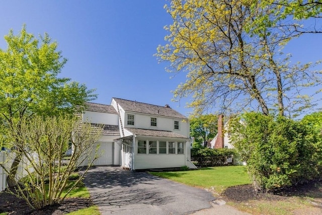 view of front facade featuring driveway, a front yard, and a garage