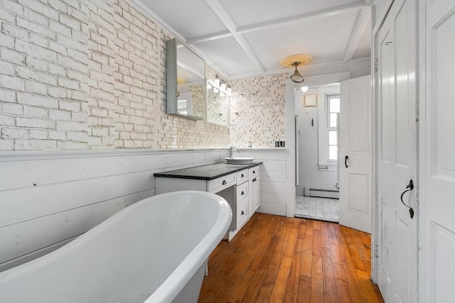bathroom featuring a freestanding tub, hardwood / wood-style flooring, vanity, a baseboard radiator, and coffered ceiling