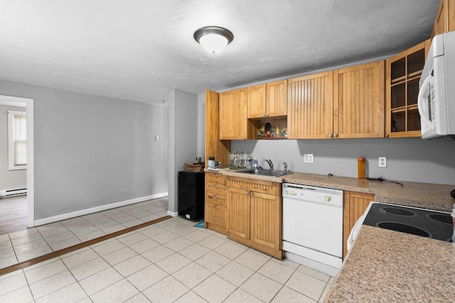 kitchen with white appliances, a sink, light tile patterned floors, and light countertops