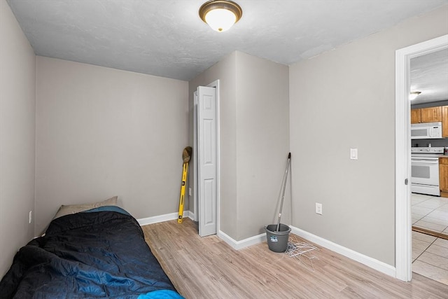unfurnished bedroom with baseboards and light wood-style floors