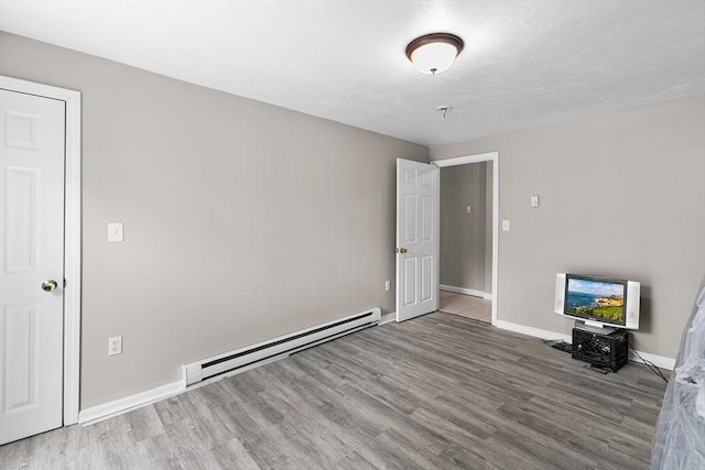 interior space featuring baseboards, wood finished floors, and baseboard heating