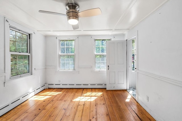 empty room featuring baseboard heating, a ceiling fan, and light wood-style flooring