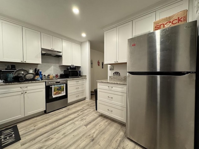 kitchen with white cabinetry, light stone countertops, stainless steel appliances, light hardwood / wood-style flooring, and decorative backsplash