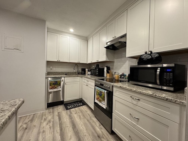 kitchen with white cabinets, stainless steel appliances, and light stone counters