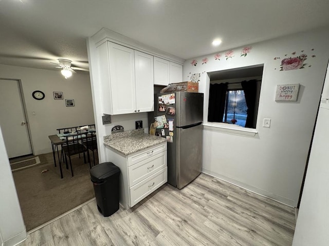 kitchen featuring stainless steel fridge, light hardwood / wood-style floors, white cabinetry, and ceiling fan