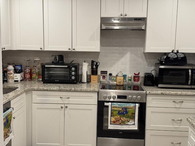 kitchen with white cabinets, light stone countertops, appliances with stainless steel finishes, and tasteful backsplash