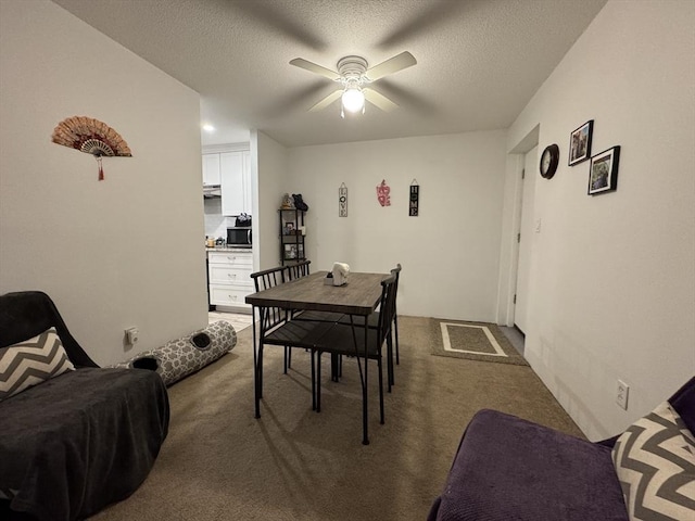 dining room with ceiling fan, carpet floors, and a textured ceiling