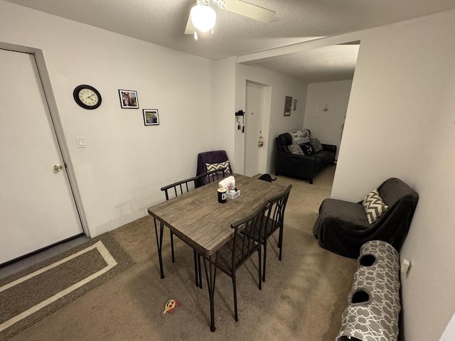 carpeted dining room featuring a textured ceiling and ceiling fan