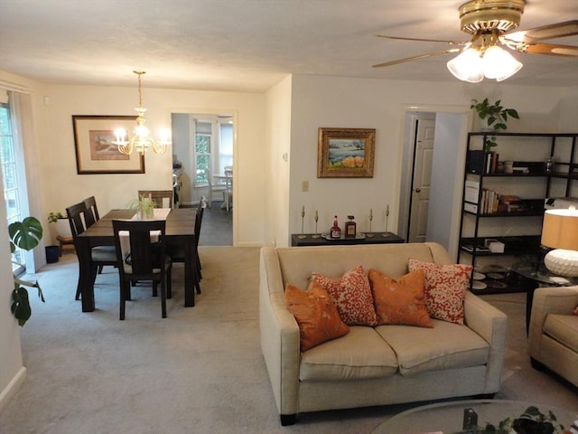 living area featuring plenty of natural light, a chandelier, carpet flooring, and ceiling fan