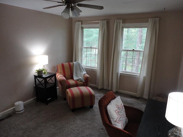 living area with ceiling fan, baseboards, and carpet floors