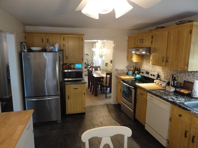 kitchen with stainless steel appliances, under cabinet range hood, backsplash, a ceiling fan, and a chandelier