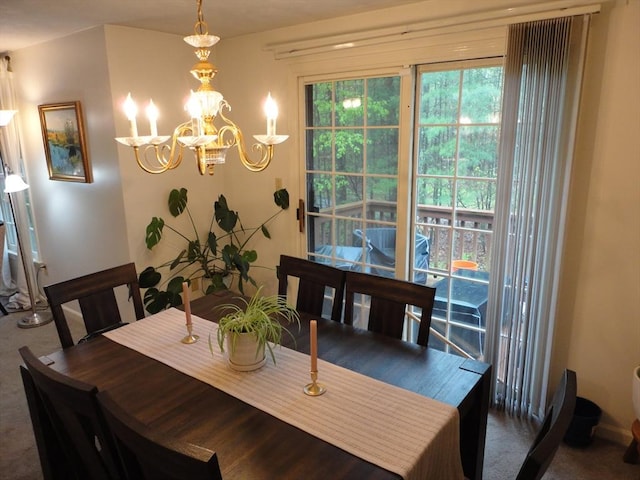 dining space with a chandelier and carpet floors