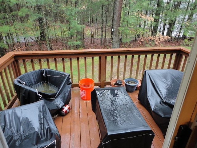 deck featuring a lawn and a wooded view