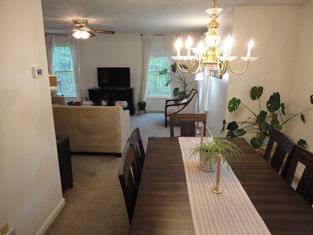 carpeted dining room featuring plenty of natural light, a chandelier, a ceiling fan, and baseboards