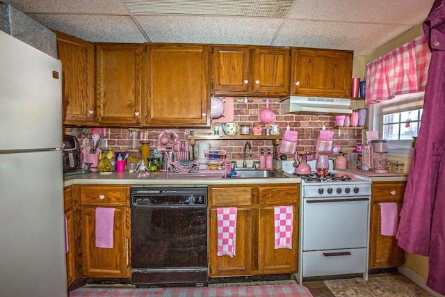 kitchen featuring white appliances, a drop ceiling, sink, and backsplash