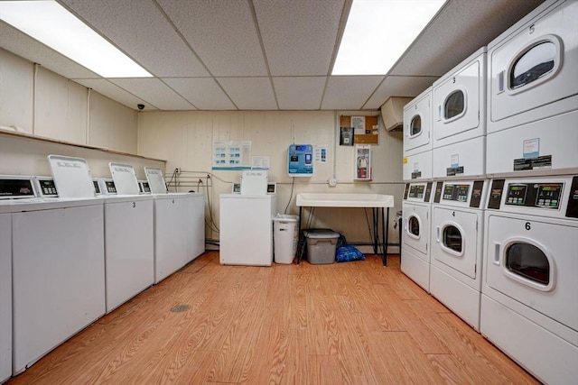 washroom with independent washer and dryer, stacked washing maching and dryer, and light hardwood / wood-style floors