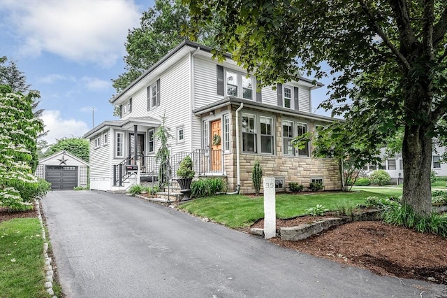 35 Warren Ave, Reading, MA 01867 - american foursquare style home featuring stone siding, an outdoor structure, asphalt driveway, a detached garage, and a front yard