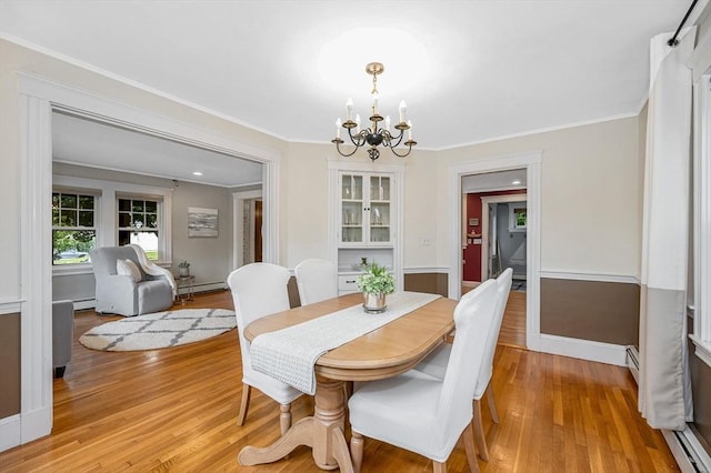 35 Warren Ave, Reading, MA 01867 - dining space featuring a chandelier, light wood-style floors, a baseboard radiator, ornamental molding, and baseboards