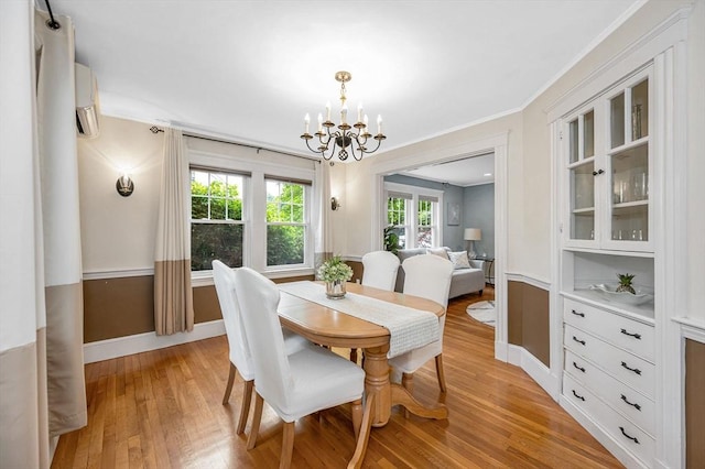 35 Warren Ave, Reading, MA 01867 - dining space featuring a chandelier, light wood-type flooring, baseboards, ornamental molding, and a wall mounted AC