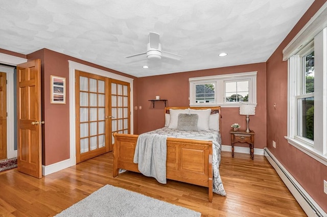 35 Warren Ave, Reading, MA 01867 - bedroom with a baseboard radiator, multiple windows, french doors, light wood finished floors, and recessed lighting