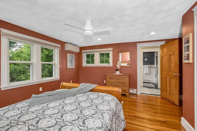 35 Warren Ave, Reading, MA 01867 - bedroom with a baseboard heating unit, a wall unit AC, light wood-type flooring, multiple windows, and recessed lighting