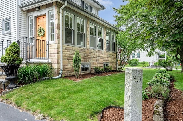 35 Warren Ave, Reading, MA 01867 - view of side of home featuring stone siding and a lawn
