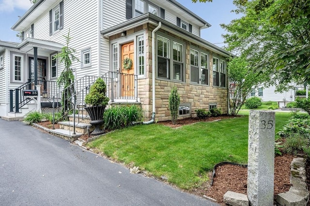 35 Warren Ave, Reading, MA 01867 - view of front facade with stone siding and a front yard