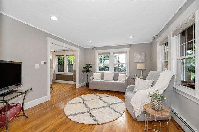 35 Warren Ave, Reading, MA 01867 - living room featuring a baseboard heating unit, ornamental molding, baseboards, light wood-style floors, and recessed lighting