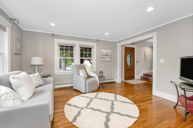 35 Warren Ave, Reading, MA 01867 - living area featuring a baseboard heating unit, light wood-style floors, ornamental molding, baseboards, and a baseboard radiator