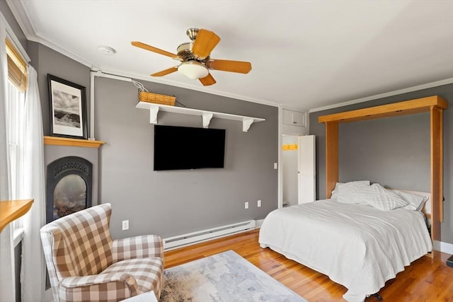 150 Prospect St Unit 3, Gloucester, MA 01930 - bedroom featuring a baseboard radiator, ornamental molding, wood finished floors, a large fireplace, and ceiling fan