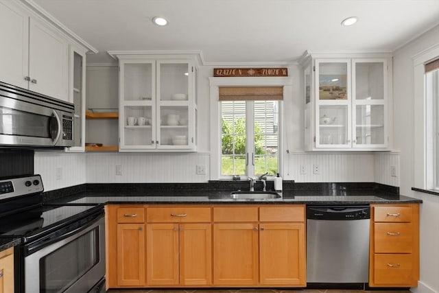 150 Prospect St Unit 3, Gloucester, MA 01930 - kitchen featuring appliances with stainless steel finishes, dark stone counters, glass insert cabinets, crown molding, and recessed lighting