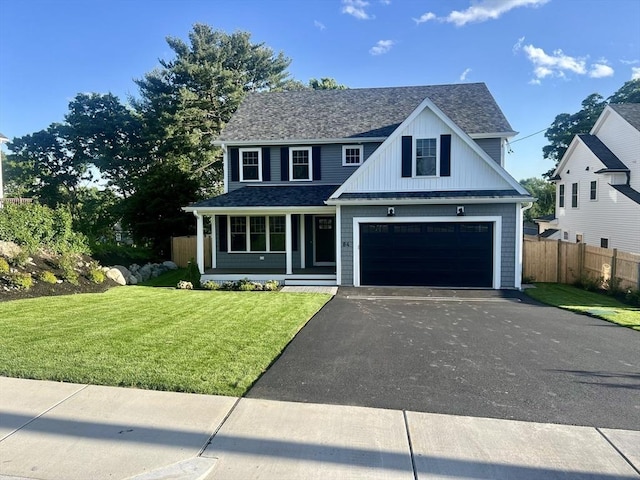 view of front of home with a front lawn, covered porch, and a garage