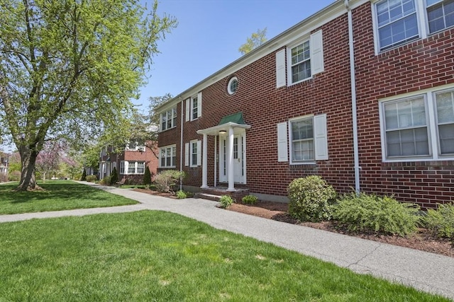 view of front of property featuring brick siding and a front lawn