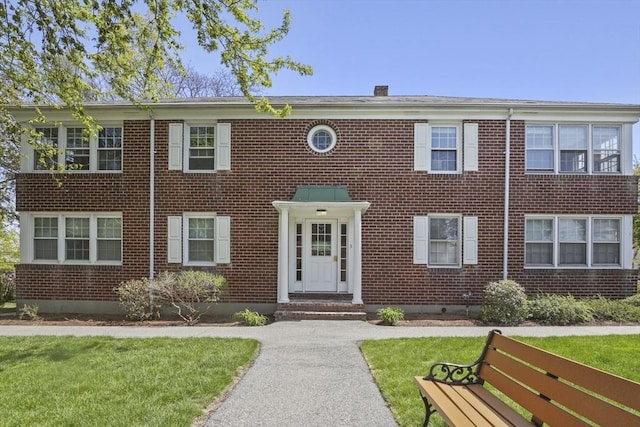 view of front of house featuring brick siding and a front yard