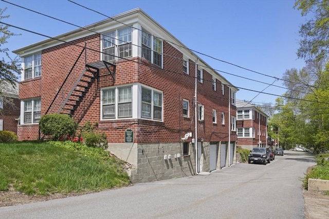 view of home's exterior featuring brick siding, an attached garage, and aphalt driveway