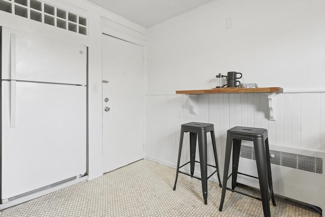 interior space with radiator heating unit and a wainscoted wall