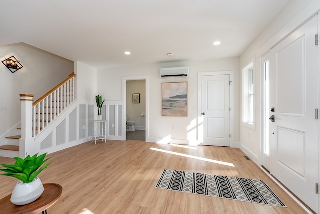 entryway featuring light wood-type flooring and a wall mounted AC