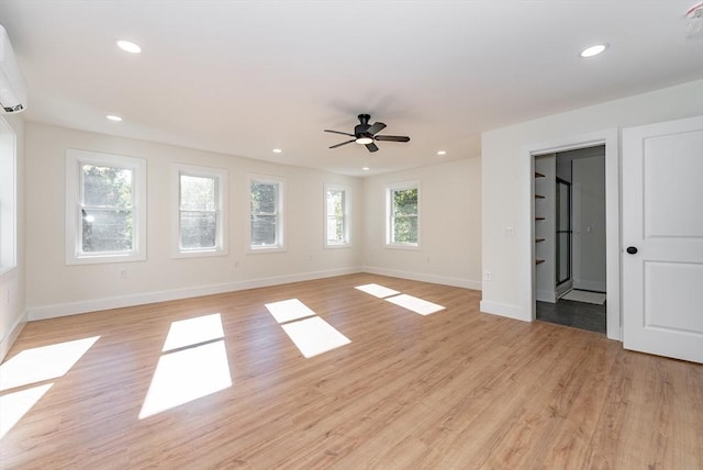 unfurnished living room featuring a ceiling fan, baseboards, and light wood-style floors