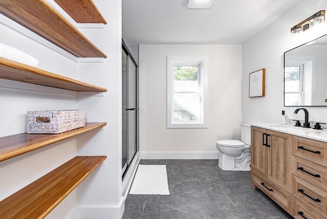 bathroom featuring vanity, baseboards, a stall shower, and toilet