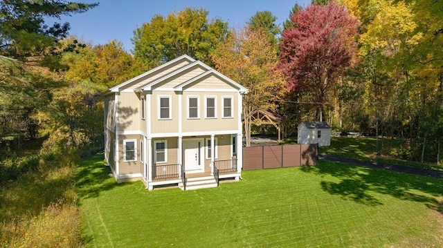 back of house featuring a lawn and covered porch