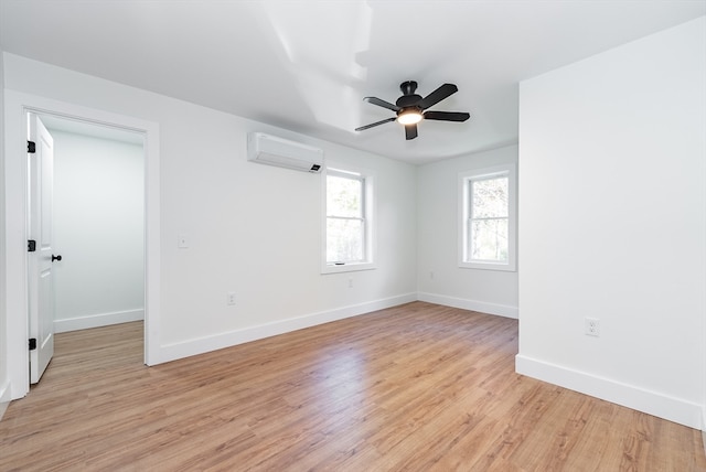 empty room with an AC wall unit, ceiling fan, and light hardwood / wood-style flooring