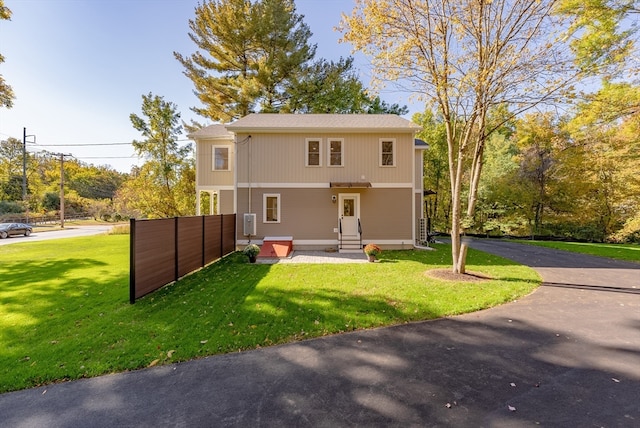 rear view of house featuring a lawn