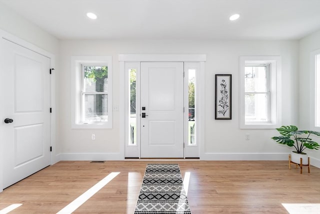 entryway featuring light wood-type flooring, baseboards, and visible vents