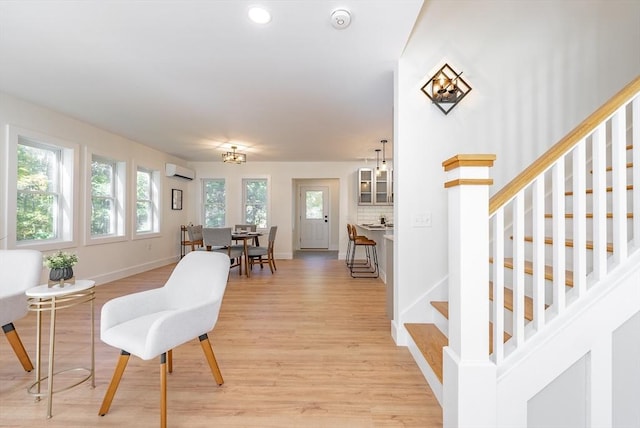 interior space with baseboards, stairway, light wood-type flooring, recessed lighting, and a wall unit AC