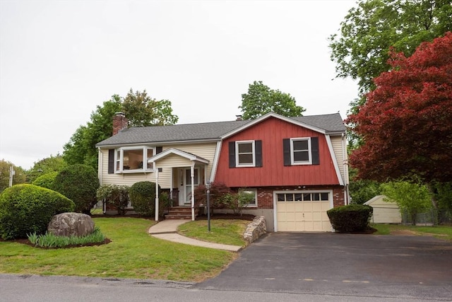 bi-level home featuring an attached garage, asphalt driveway, a chimney, a front lawn, and a gambrel roof