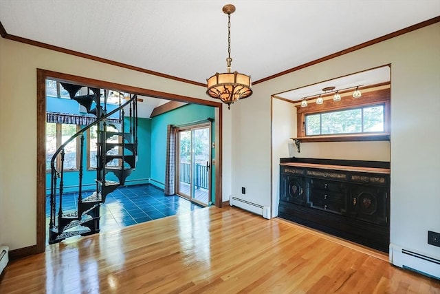 interior space with wood-type flooring, baseboard heating, and crown molding